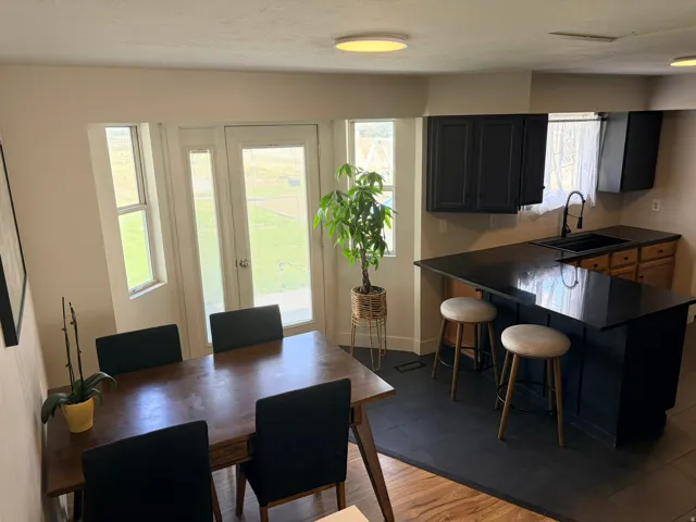 Kitchen with dark cabinetry, dark L-shaped island, and dark countertops