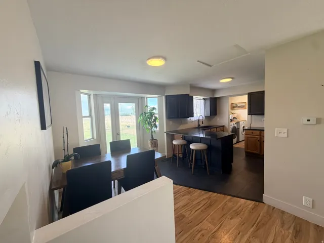 Kitchen with dark cabinetry, an island with countertop seating, and dark tile flooring