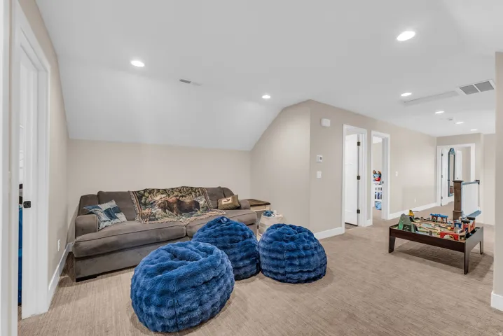 Carpeted recreation room with recessed lighting, neutral wall tones, and white trim