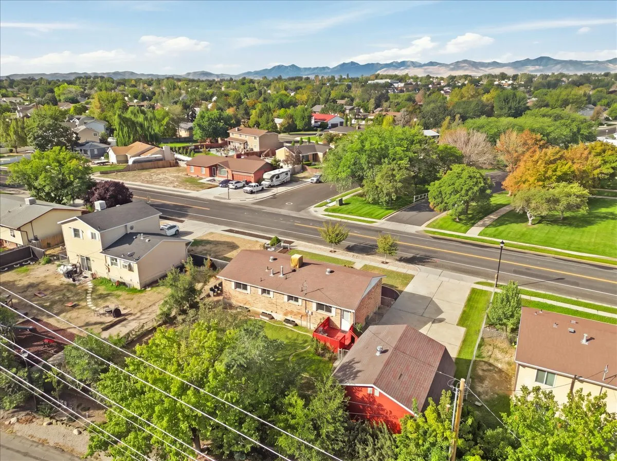 Residential street with established landscaping and mountain backdrop