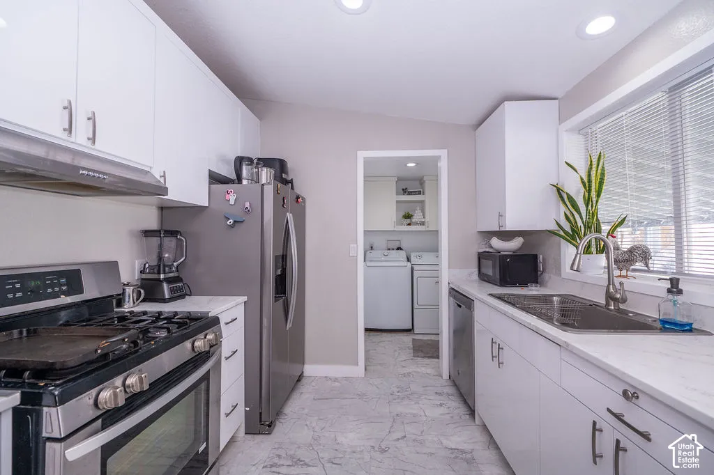 Kitchen featuring white cabinetry, light-toned countertops, stainless steel appliances, and recessed lighting