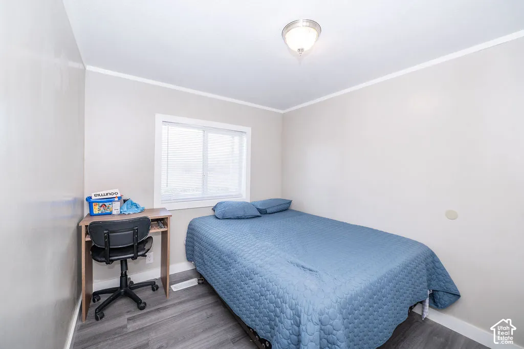 Ceiling-mounted light fixture, white trim, window with blinds, and wood-finish flooring