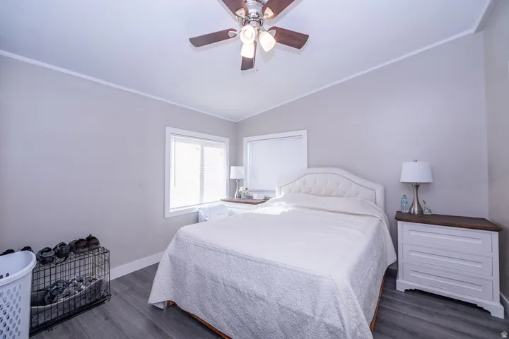 Wood-finish flooring with a ceiling fan and two windows