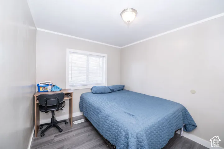 Ceiling-mounted light fixture, white trim, window with blinds, and wood-finish flooring