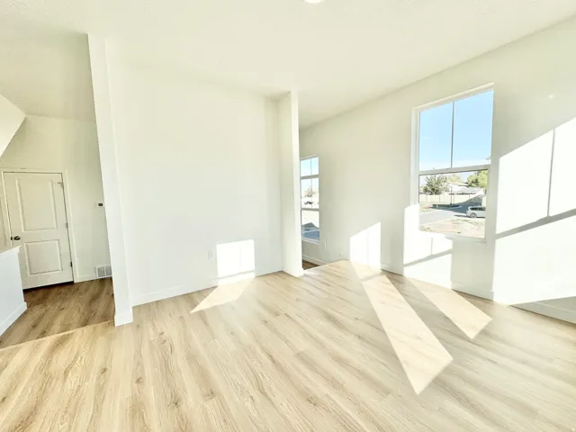 Wood-finish flooring throughout, white interior doors, and multiple windows