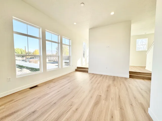 Bright interior with wood-finish flooring, recessed lighting, and multiple large windows