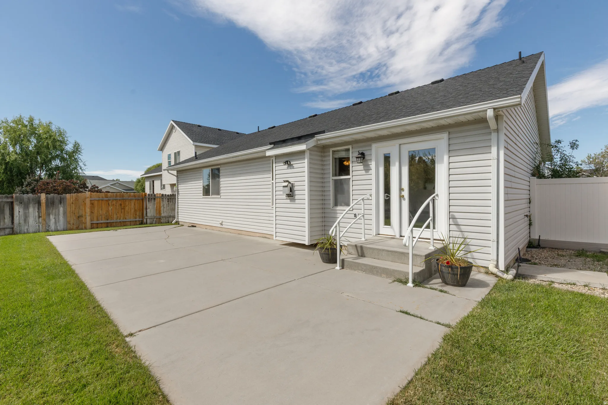 Expansive concrete patio with direct outdoor access via double glass-paned doors