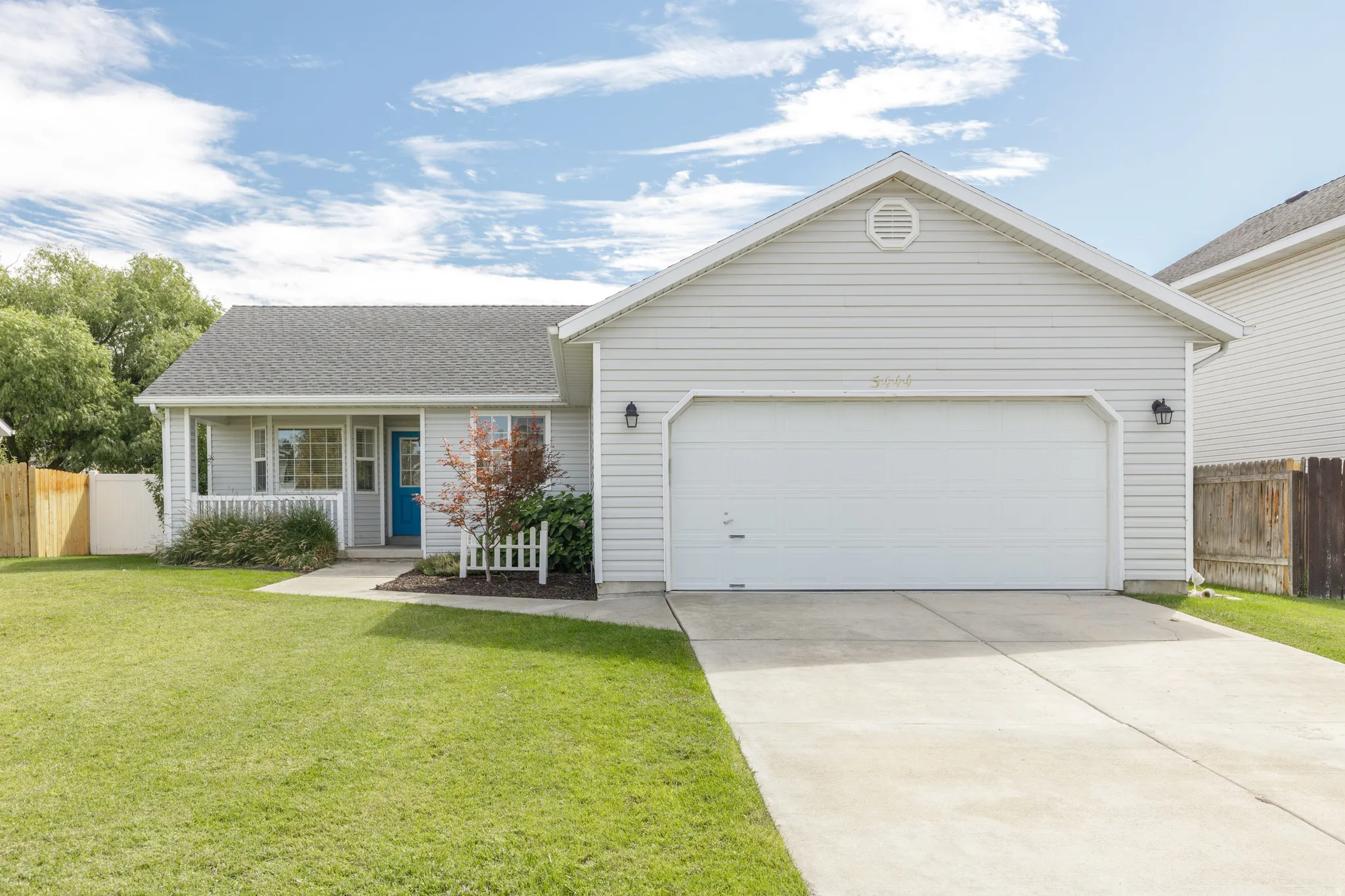 Siding exterior with a covered porch, attached garage, and a concrete driveway