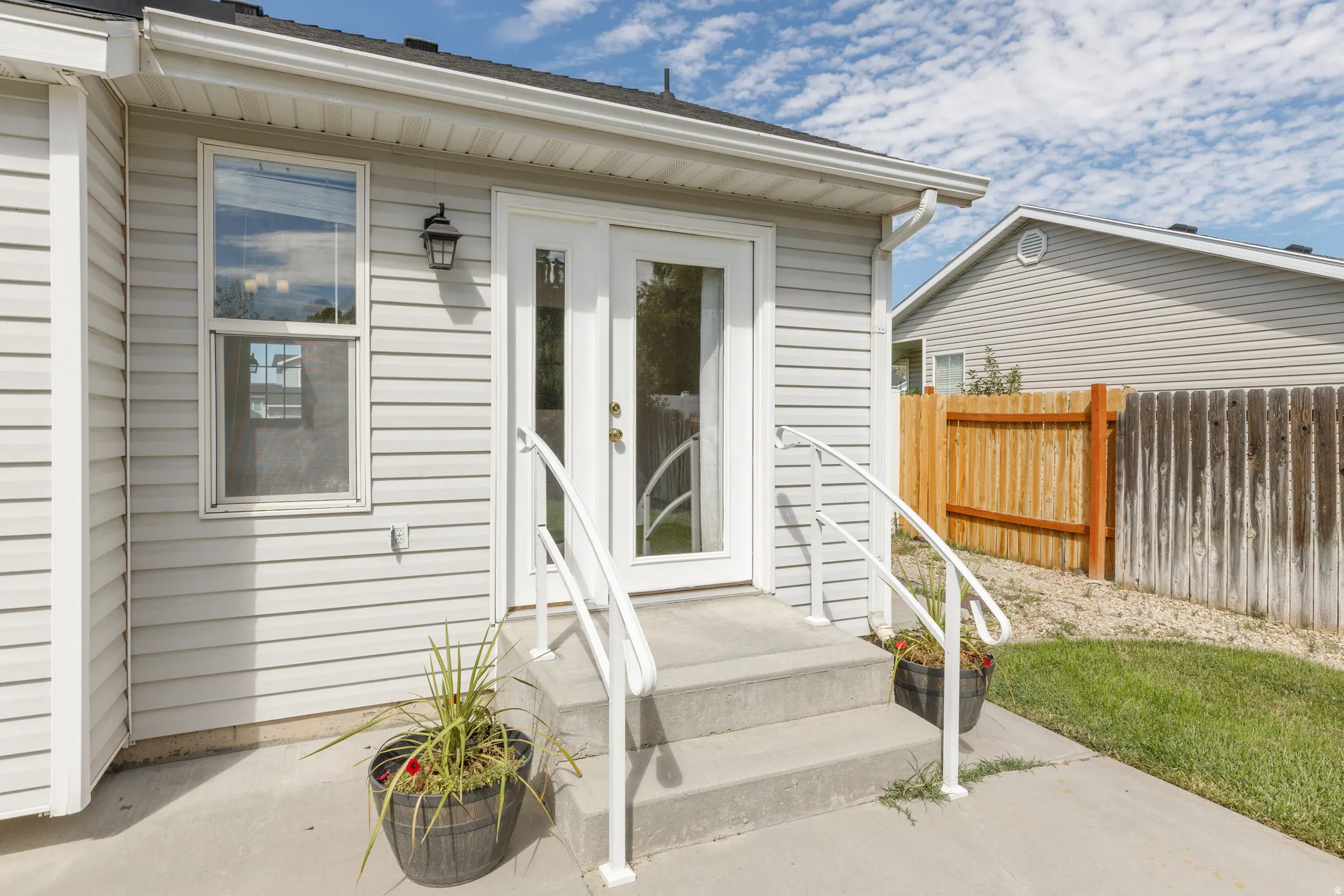 White vinyl siding exterior with an attached outdoor wall lantern