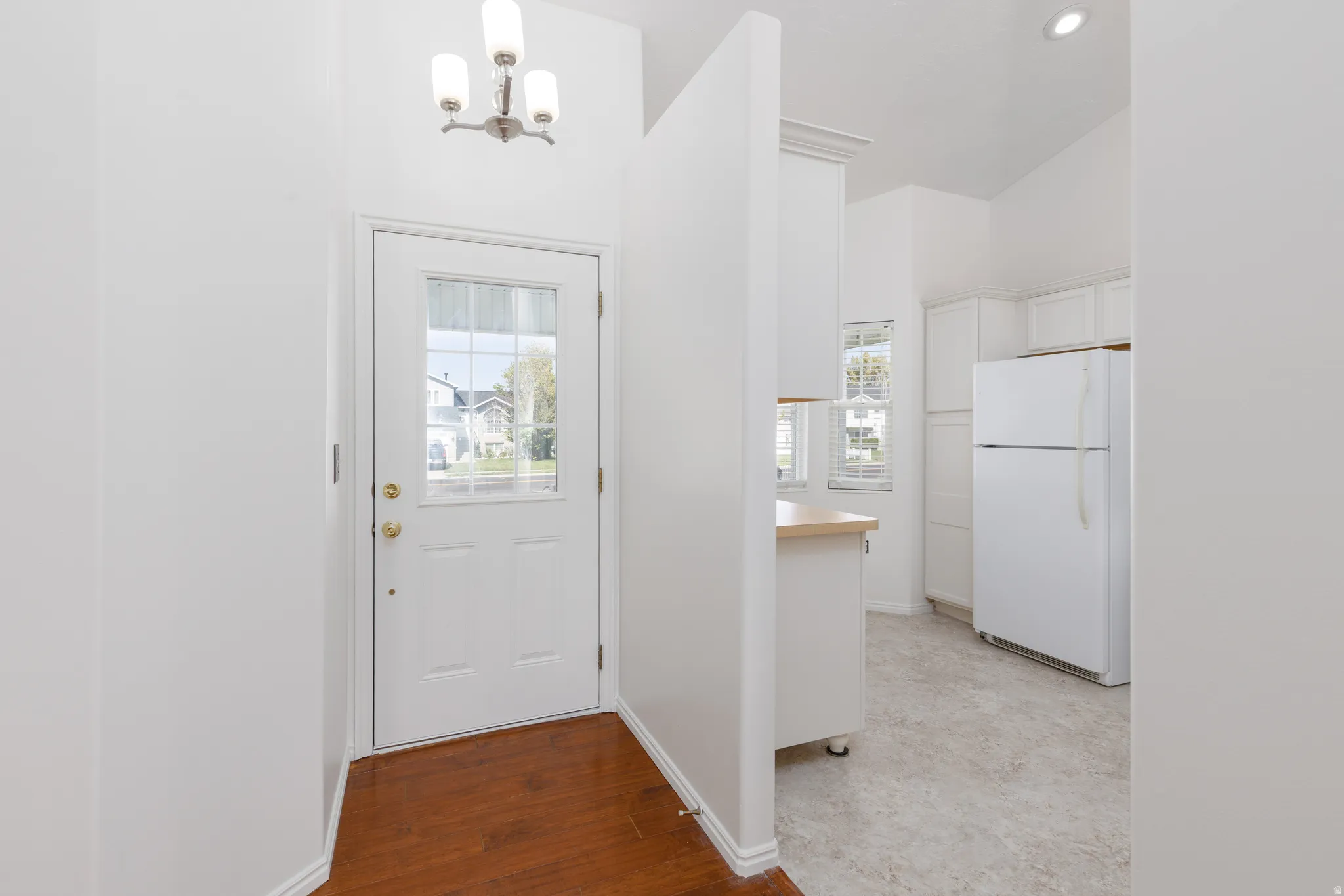 Entryway with wood-finish flooring and a decorative chandelier