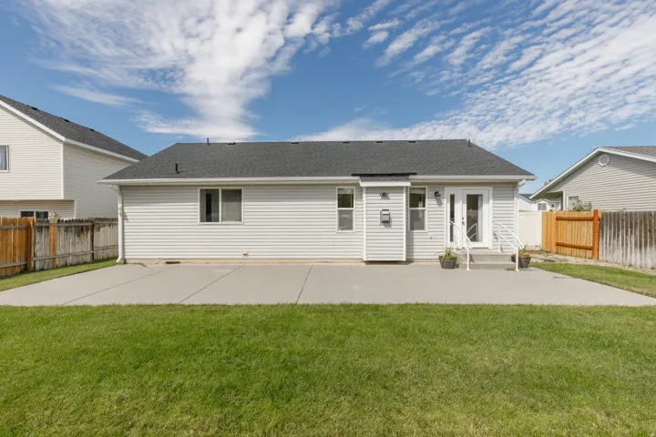 Expansive rear concrete patio with direct access to the interior via double French doors