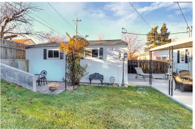 Backyard featuring a grass lawn, concrete patio, and a covered patio area