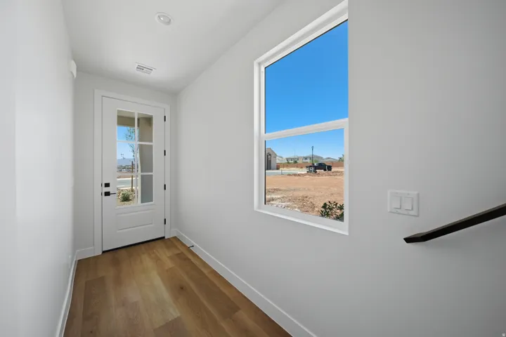 Wood-finish flooring, white walls, and a recessed ceiling light