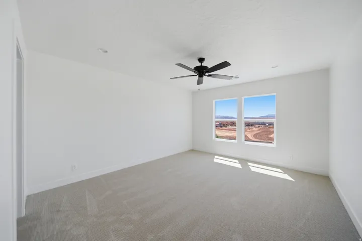 Bright room with two windows, a ceiling fan, and recessed lighting