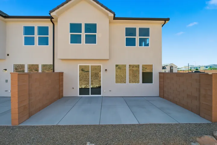 Stucco exterior with multiple windows and a sliding glass door