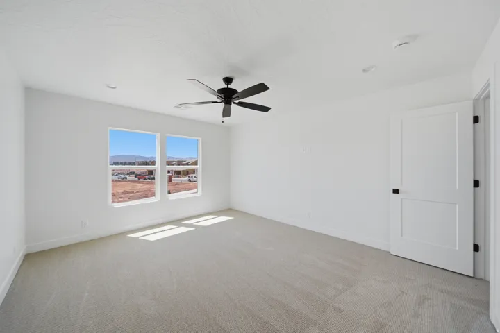 Two large windows, ceiling fan with matte black finish, recessed lighting, and a flat panel door with black hardware