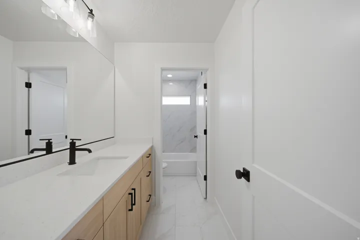 Extended vanity with a light-toned countertop and wood-finish cabinetry