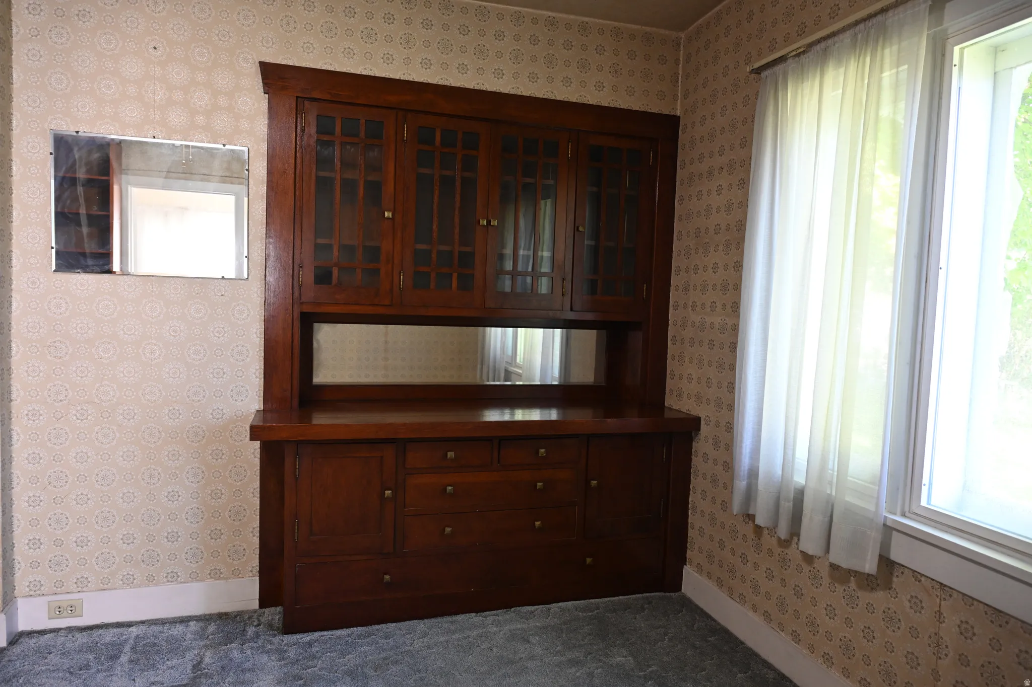 Built-in wooden cabinetry with glass-front upper doors and lower drawers