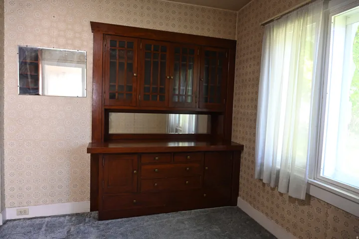 Built-in wooden cabinetry with glass-front upper doors and lower drawers