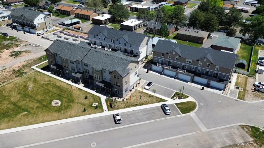 Modern townhome community featuring multi-story units, attached garages, private balconies, and landscaped common areas