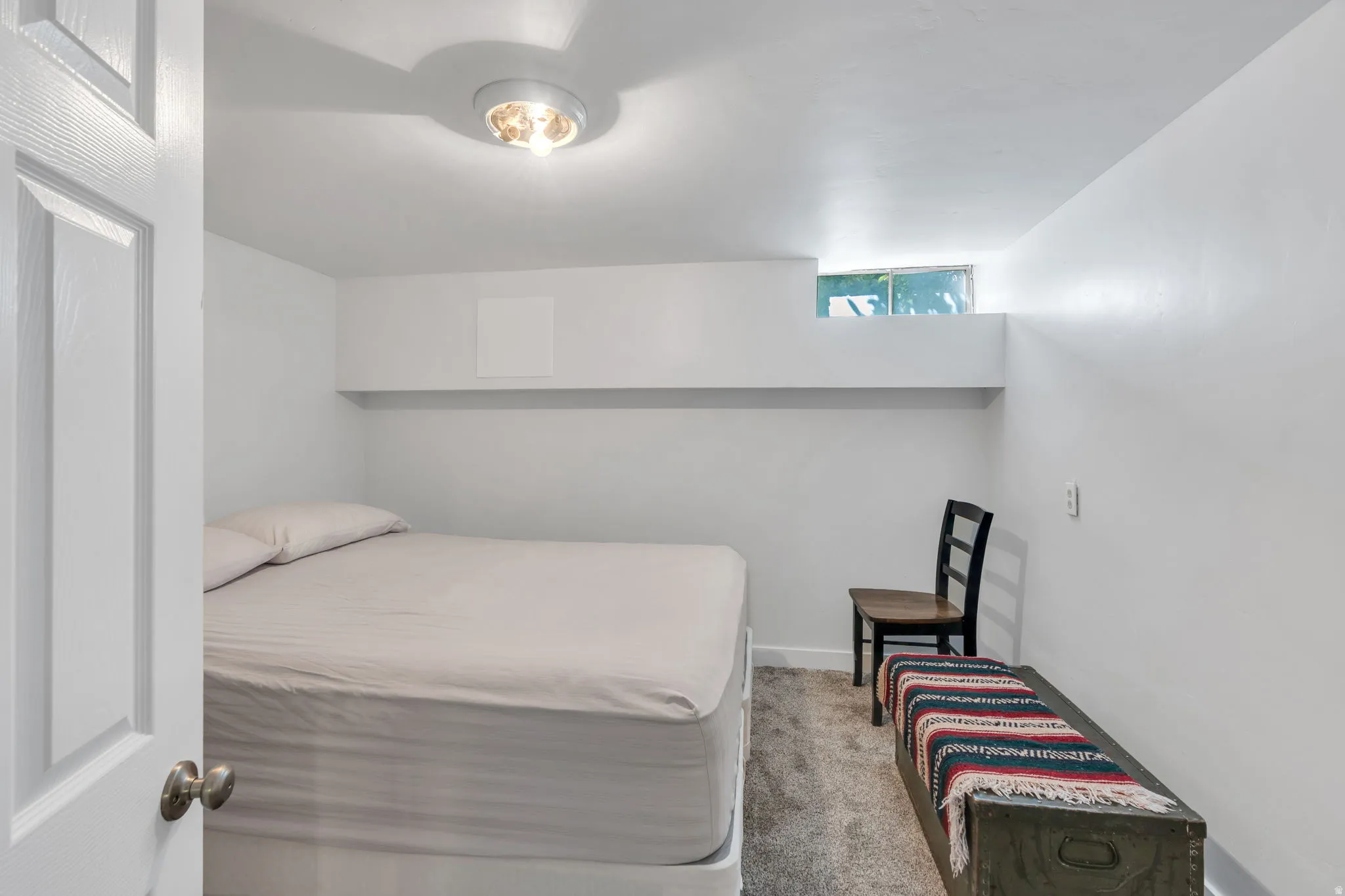 Recessed window, built-in shelving, overhead ceiling light, and wall-to-wall carpeting