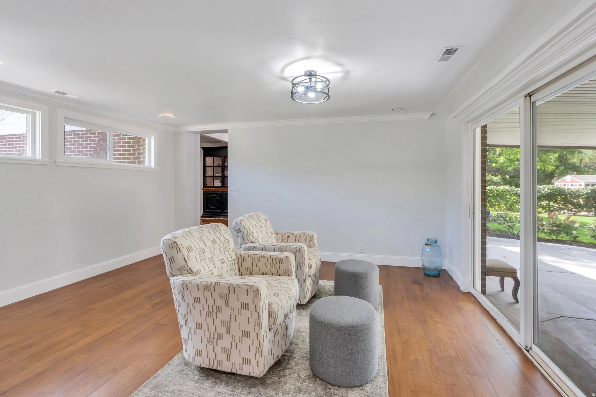 Wood-finish flooring, white walls, and crown molding