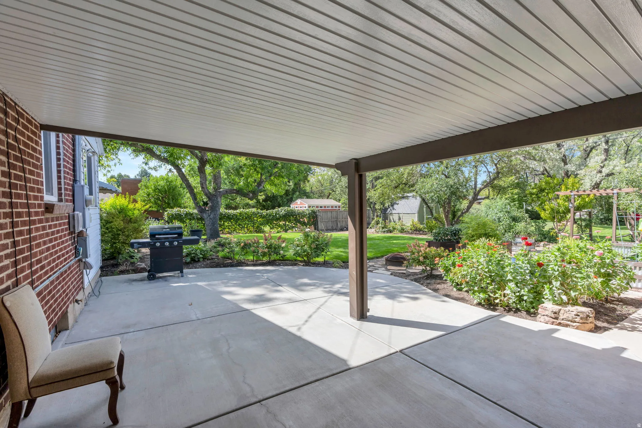 Covered patio featuring a solid roof, structural support beams, and a concrete surface