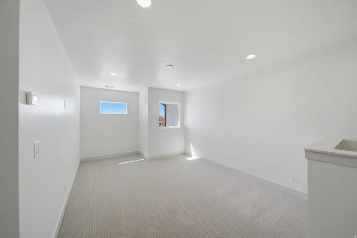 Wall-to-wall carpeting, recessed lighting, and multiple windows