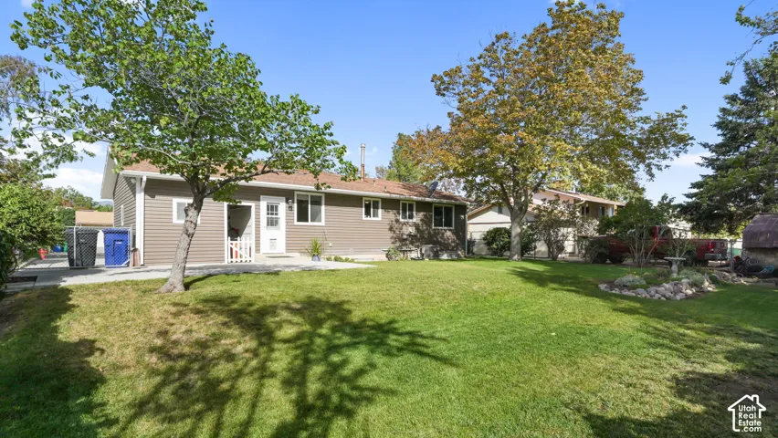 Expansive green lawn with mature trees and established landscaping