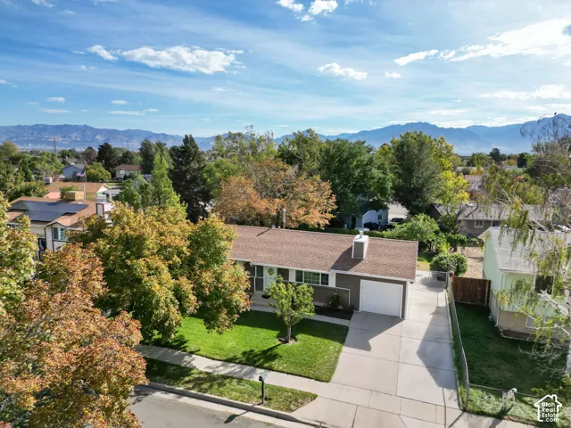 Single-story residence with an attached garage, paved driveway, and established front lawn