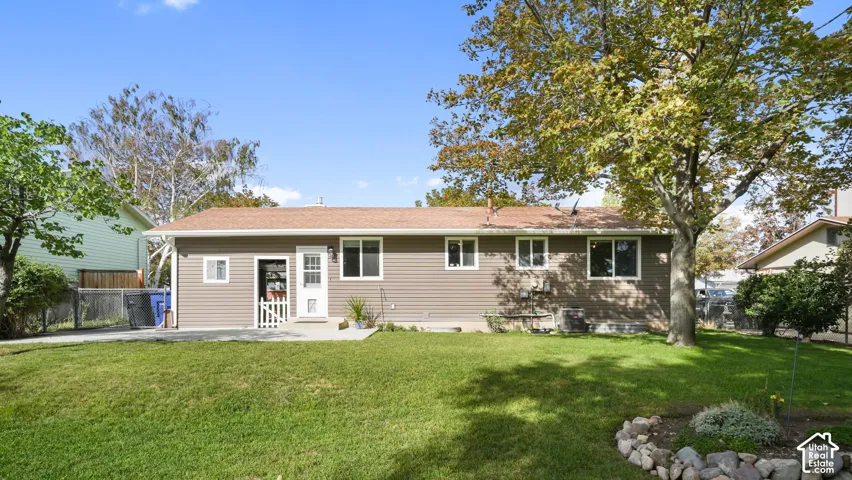 Expansive lawn with mature trees and a stone-lined garden bed