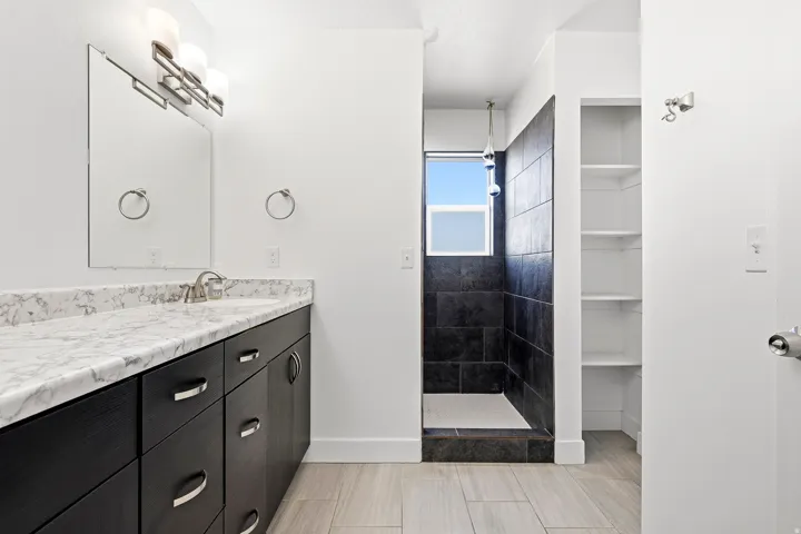 Vanity with stone countertop, undermount sink, and brushed nickel fixtures