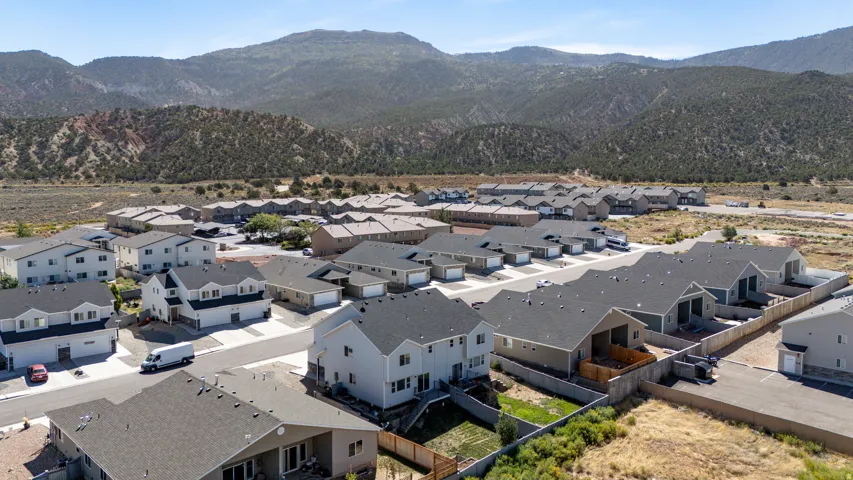 Expansive residential development with diverse architectural styles, hardscaping, and surrounding mountainous terrain