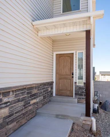Entryway featuring a wood-finish door, sidelight window, and a covered porch