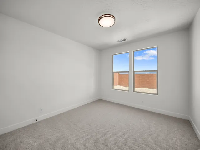 Light-colored carpeting, white walls, and a contemporary ceiling light fixture