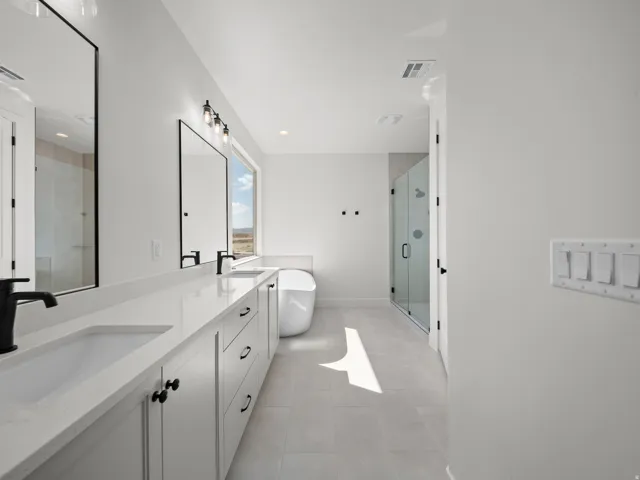 Dual vanity with undermount sinks, stone countertops, and matte black fixtures