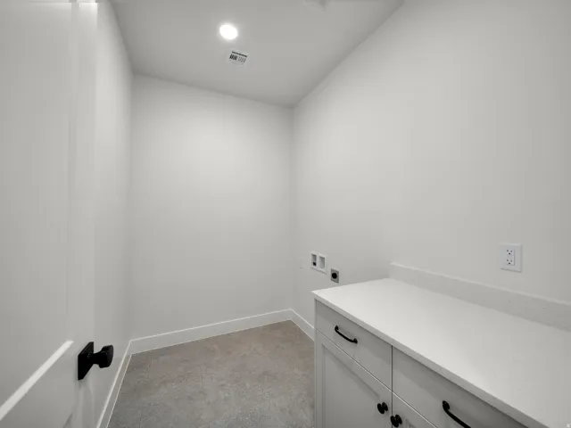 Laundry area featuring a built-in cabinet with a light-colored countertop, recessed ceiling lighting, and carpet flooring