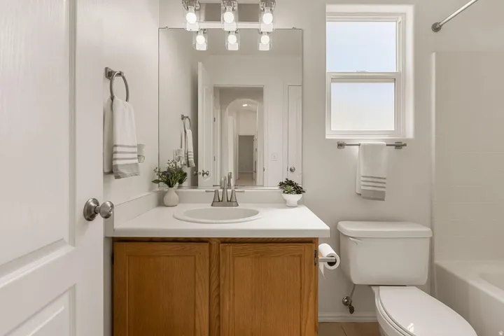 Bathroom featuring a single vanity with wood cabinetry, a white countertop, and a rectangular mirror
