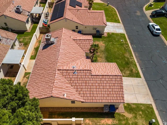 Red tile roofing with solar panels and a concrete driveway