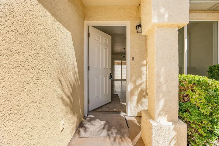 Stucco exterior finish with a paneled entry door and an exterior light fixture