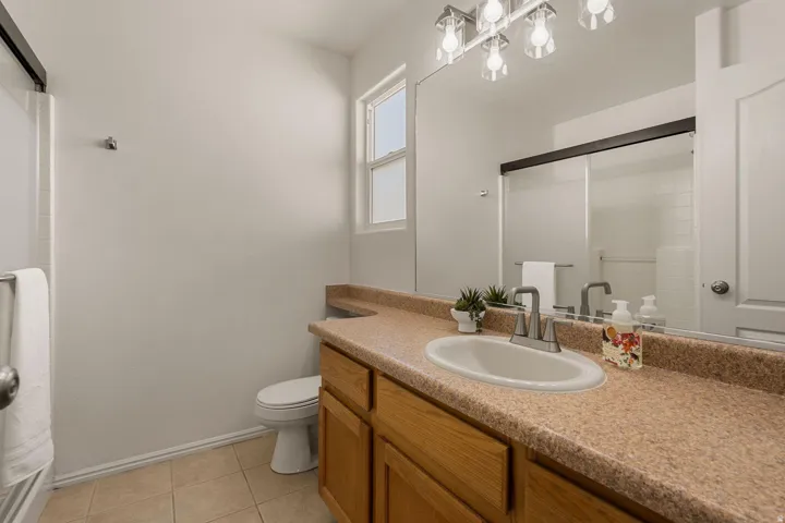 Vanity with an integrated sink, broad mirror, and overhead light fixture