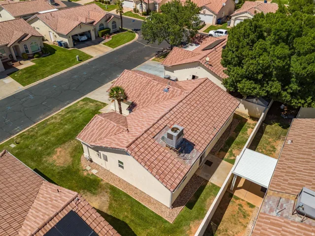 Tiled roof, stucco exterior, mature palm tree, manicured lawn, and paved driveway