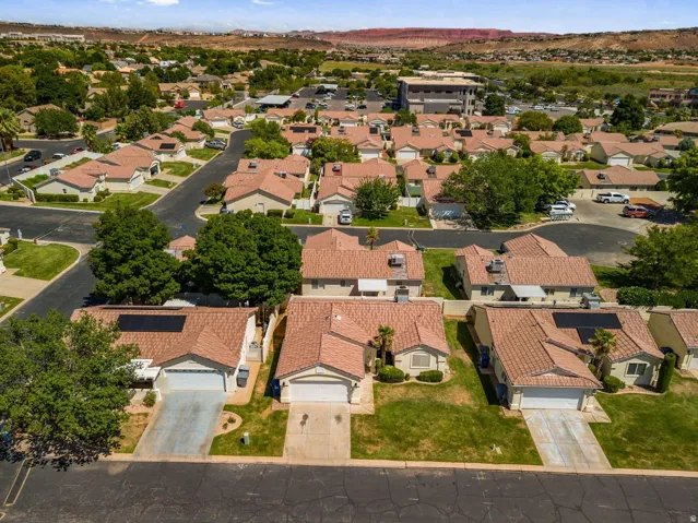 Residential neighborhood with single-story homes, terracotta-style roofing, attached garages, and landscaped front yards