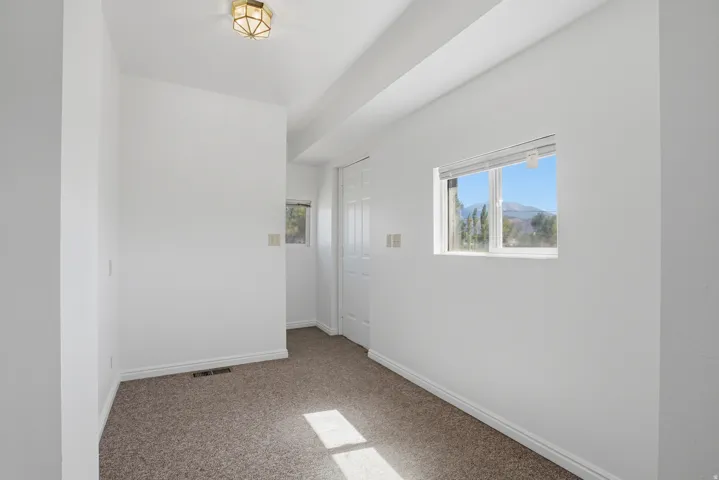 Carpeted flooring, white walls, and a window with mountain scenery