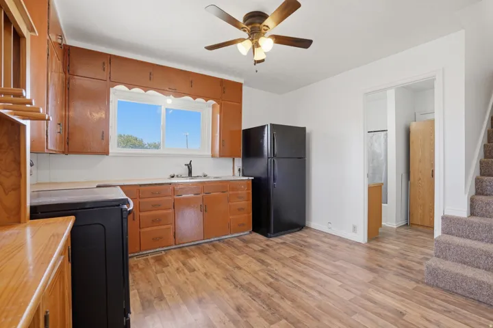 Kitchen featuring wood-finish flooring, ample cabinetry, and a ceiling fan