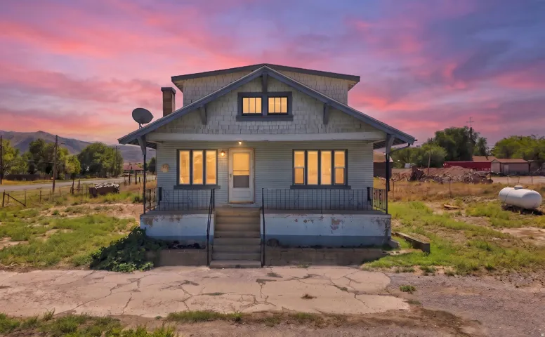 Two-story residence with a front porch, exterior steps, and multiple windows
