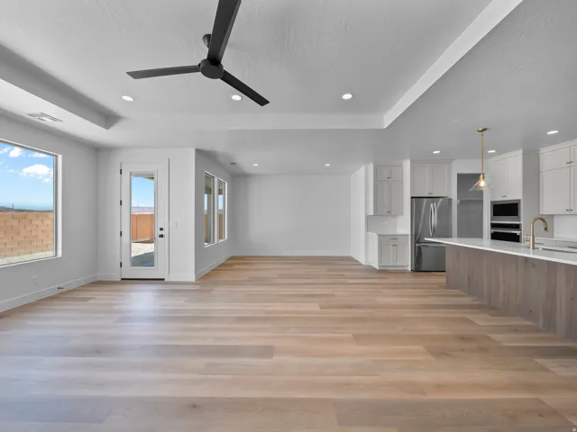 Open-concept living space with wood-finish flooring, recessed lighting, and a modern ceiling fan