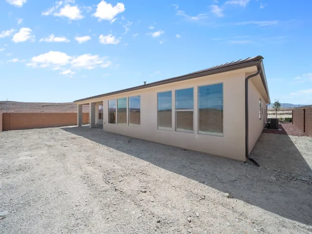 Neutral stucco exterior with a covered patio and multiple large windows