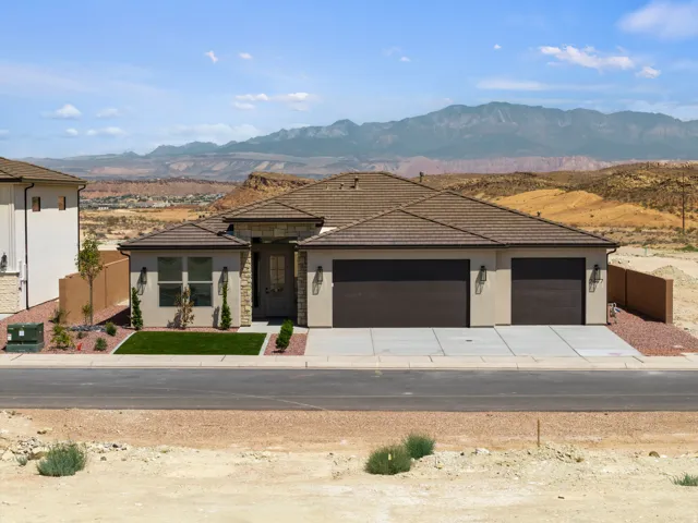 Contemporary stucco exterior with stone accents and a multi-car driveway