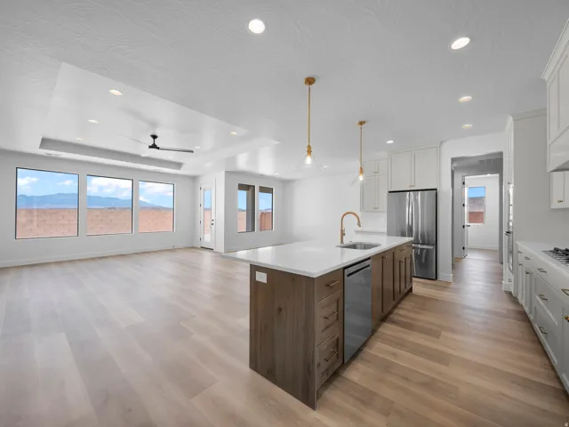 Open concept living space with wood-finish flooring, a tray ceiling, and recessed lighting